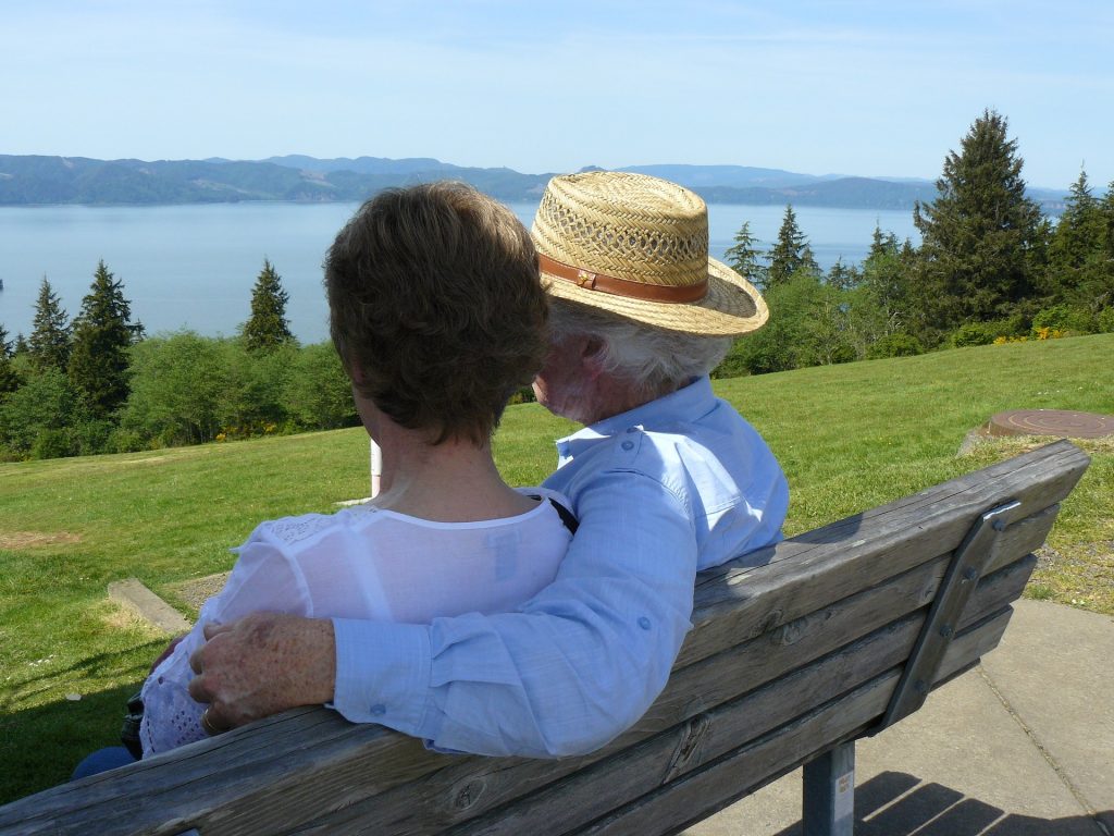 grand parents heureux assis sur un banc en face du Saint-Laurent après avoir obtenu un super visa par immigration Canada pour rejoindre leur enfant au Québec